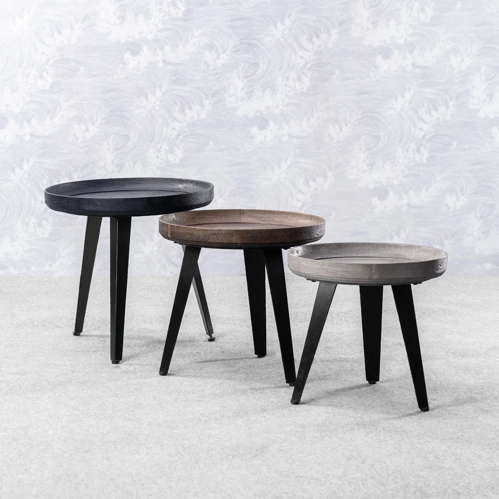 A trio of round timber and metal tables by Dhvij International